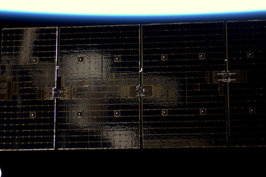 Soyuz reflected in Dragon solar array