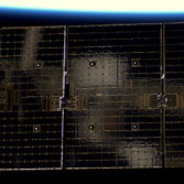 Soyuz reflected in Dragon solar array