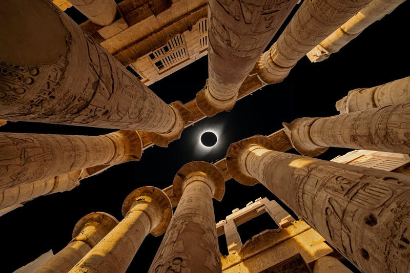 Total solar eclipse over Egyptian pillars