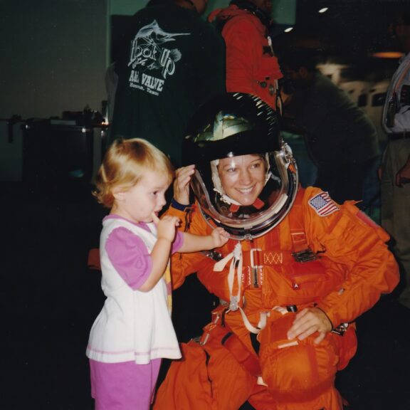 Eileen collins in space suit with bridget age 3